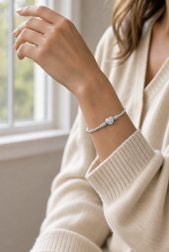 Woman wearing a heart clasp bracelet by a window
