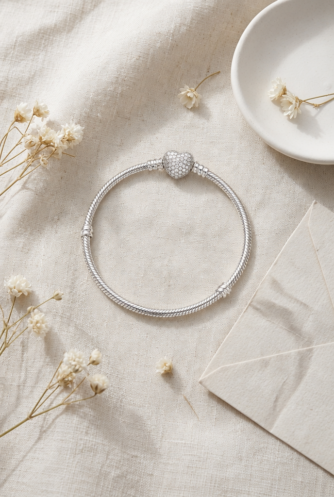 Heart clasp bracelet beside a handwritten note and dried flowers